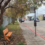 wooden bench next to bus stop 