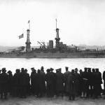 View of crowds gathered at the 96th Street Pier to watch the USS Arizona leading the fleet in a naval review for Secretary of the Navy Josephus Daniels, upon the fleet's arrival home at the end of the First World War, NY December 1918.
