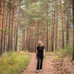 Woman connecting with nature, forest bathing. 