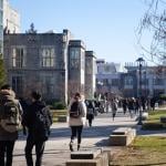 Students walking between classes in a university campus.