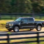 A black 2022 Ford F-150 hybrid pickup truck driven on-road.