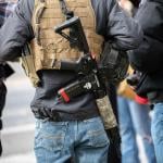 People photographed form behind with guns on their back in Carson City, Nevada.