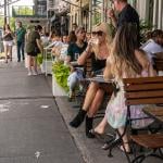 Diners during the day in a lane in New York City enjoying some alfresco dining.