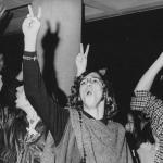 Students wearing hippie attire and holding their fingers aloft in a peace sign gesture during an anti-Vietnam War student sit-in protest at North Carolina State University in 1970.