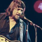 Country singer Waylon Jennings performing on stage.
