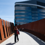 Students cross a pedestrian bridge to the EXP building at Northeastern University, which houses science, engineering and computational research departments.