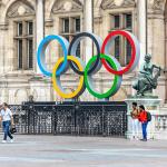 Tourists walking in the Hotel de Ville square with the Paris 2024 Olympic rings in front of the city hall in Paris, France.