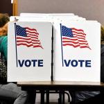 Voters sit in Virginia at a polling place, hidden by voting booth.