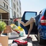 A parent packing their car with items and bags to help with college move-in day.