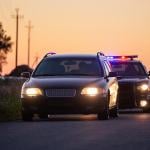 Car on the road being followed by police.