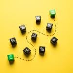 Money and stocks transfer represented by ten pieces of dice on a yellow background.