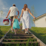 A couple with two young children going on a picnic