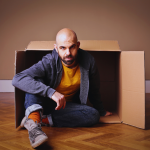 Man emerging from a cardboard box.