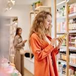 Shoppers look at beauty products in upscale store. 