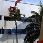 A worker in a boom lift sprays a coat of cool paint on the roof of a building at the test site in Singapore.