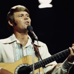 American singer Glen Campbell performs on a TV show in London, circa 1974.