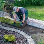 A landscaper doing maintenance on a lawn curb.