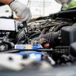 A mechanic performing repairs and maintenance on a car.