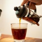 French press coffee being poured into a cup.