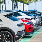 A row of different electric vehicles getting recharged at a station.