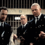 Tom Hanks (left) and David Morse (right) stands outside of a jail cell with two guards in a scene from the film 'The Green Mile', 1999.