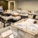 Boxes of absentee ballots are sorted by ward in a room at the Madison, Wis., City County Building in August 2020.