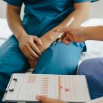 Male patient holding his crotch consults with a doctor.