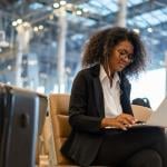 Businesswoman in airport using a laptop while waiting for flight.