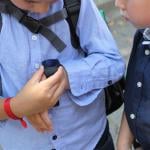 Young boy shows another child a smartwatch with a GPS tracker.