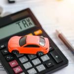 A miniature car figure on top of documents and a calculator indicating 'tax'.