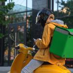 A food delivery rider looking at tasks on phone.