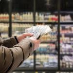 Man counting money inside a grocery store.