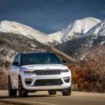 A white 2025 Jeep Grand Cherokee Summit Reserve SUV on the road.