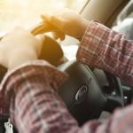 Close-up of a person's hands on a Ford steering wheel.