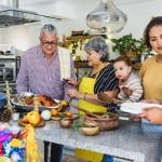 Multiple generations of a Latine family cooking together in the kitchen for the holidays.