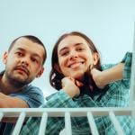 A happy couple looking into their baby's crib.