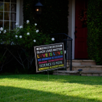 A lawn sign with the words 'Black lives matter. Love is love. No human is illegal. Science is real. Kindness is everything."