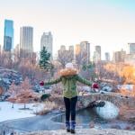 Person enjoying the view of the ice skating rink in Central Park and skyscrapers in New York City during Christmastime.