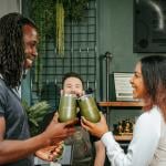 Two people sharing a toast with their Oakwell beer cups.