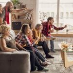 A family excitingly watching sports at home and cheering.