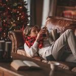 Young man lying on a couch and browsing his phone during Christmas eve.