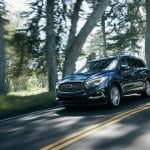 Blue 2020 INFINITI QX60 driving on the road.