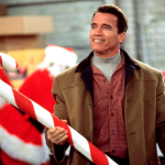 Arnold Schwarzenegger holding a giant candy cane in a scene from the movie 'Jingle All The Way'