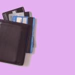 Overhead view of wallet with multiple credit cards spilling out against a pink backdrop.