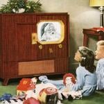 Children happily watching Santa Claus on television on Christmas circa 1950.