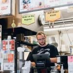 A restaurant owner manning the cash register.