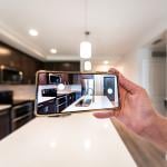 An apartment owner taking a photo of the interior of their property for marketing.