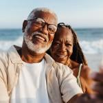 Older couple sharing a happy moment by taking selfies at the beach.