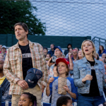 Luke Wilson and Sarah Gadon in the stands at a baseball game in a scene from 'You Gotta Believe' (2024)