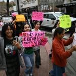 Students from Orange County Educational Arts Academy middle school hold placards in support of migrants outside the Ronald Reagan Federal Building and Courthouse in Santa Ana, California.